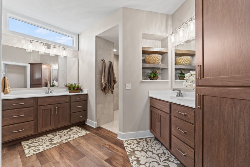 White bathroom with brown flooring a few brown towels hanging